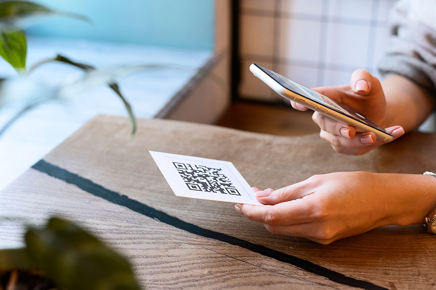 Девушка сканирует QR-код смартфоном